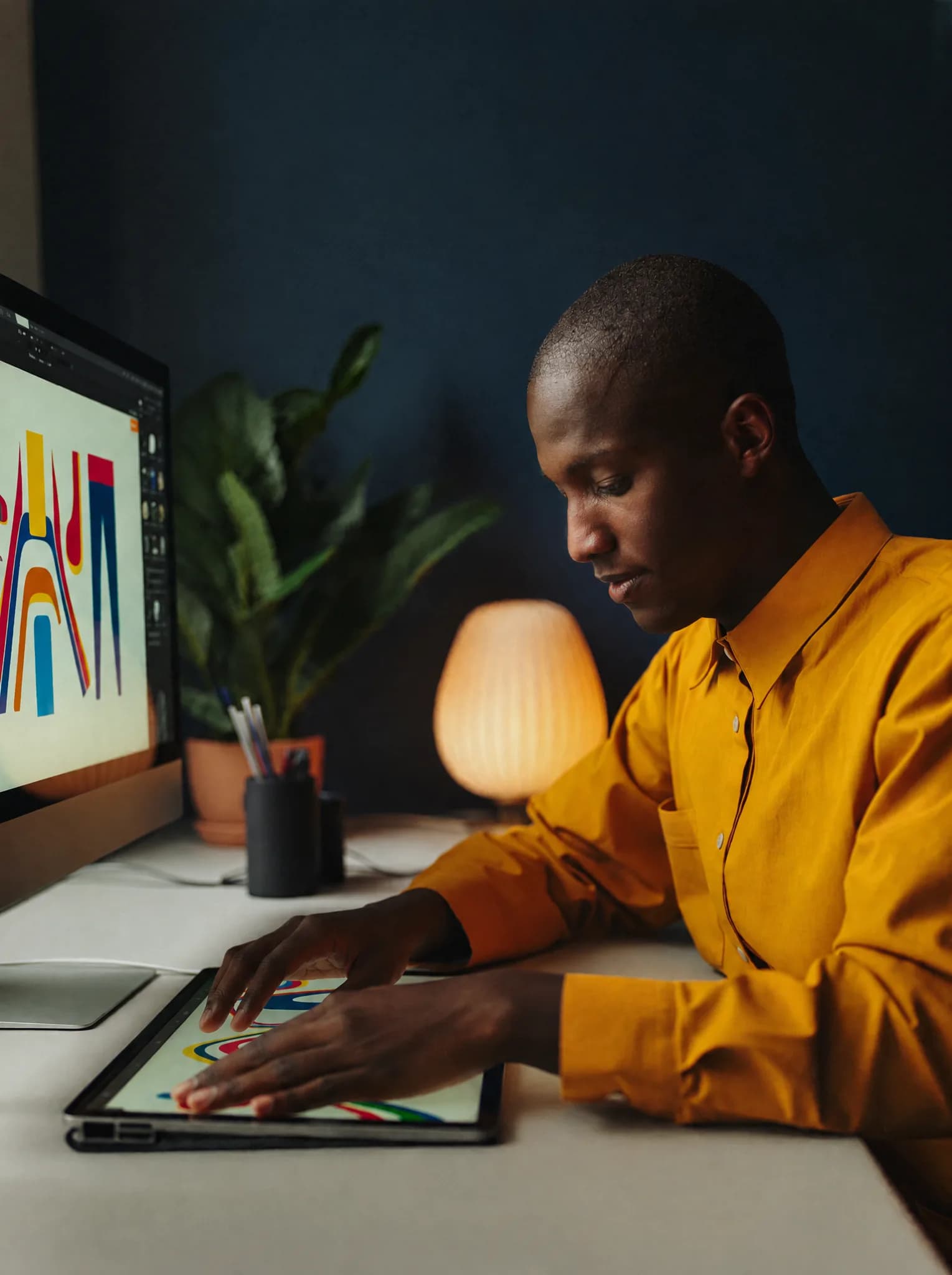 A graphic designer creating colourful artwork on a drawing tablet